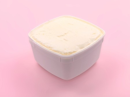A tub of vanilla icecream isolated against a pink backgroundの写真素材