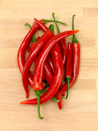 Red chilli peppers on a wooden benchの写真素材