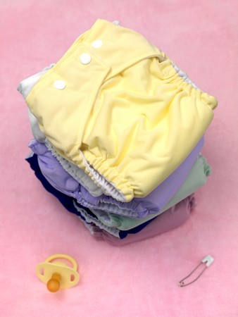 A stack of modern cloth nappies isolated against a pink backgroundの写真素材