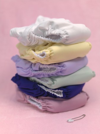 A stack of modern cloth nappies isolated against a pink backgroundの写真素材