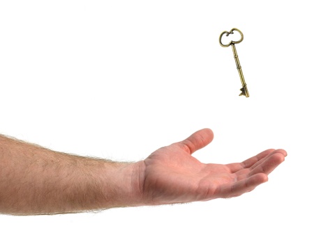 A vintage brass key isolated against a white backgroundの写真素材