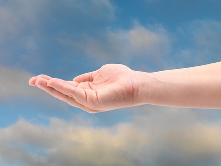 A female hand isolated against a blue skyの写真素材