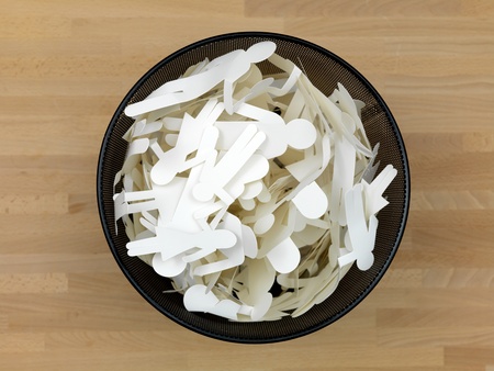 A trash bin with people cutouts isolated on a wooden floor