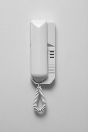 An intercom telephone on a white wall