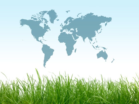 Green grass isolated against a blue sky with a world mapの写真素材