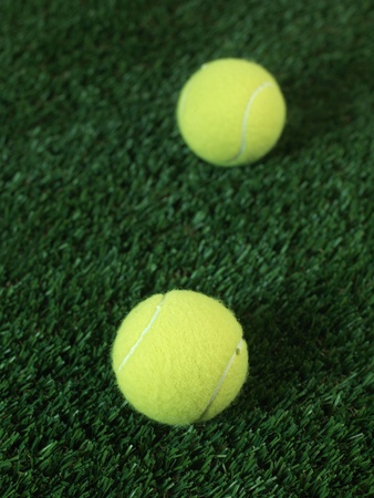 Sporting tennis balls on artificial green grassの写真素材