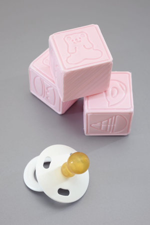 A close up shot of a child's pacifier and cubes