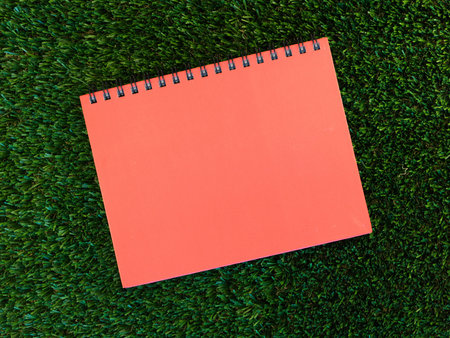 A close up shot of a note book on artificial grass