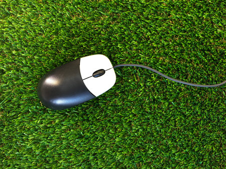 A close up shot of a computer mouse on artificial grassの写真素材