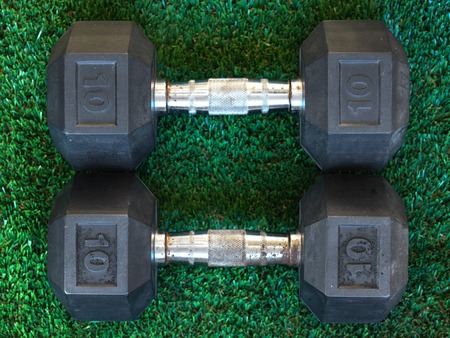 A close up shot of dumbbells on artificial grassの写真素材