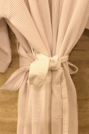A shot of a bathrobe hanging in a bathroomの写真素材