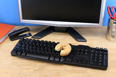 A conceptual lifestyle image of doughnuts on a work deskの写真素材
