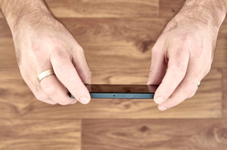 A studio photo of a mobile phone in hand