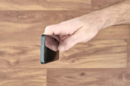 A studio photo of a mobile phone in hand