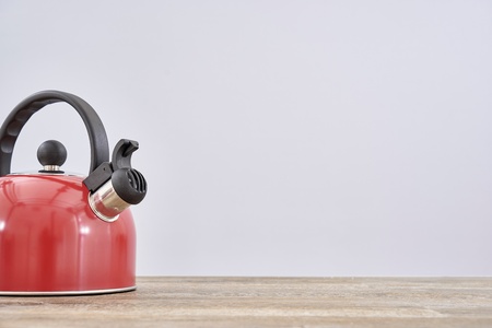 A studio photo of a red stove kettleの写真素材