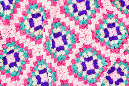 A studio photo of a hand made knitted blanket