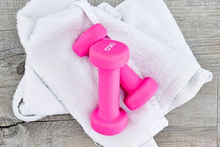 A studio photo of a pink gym dumbbellの写真素材