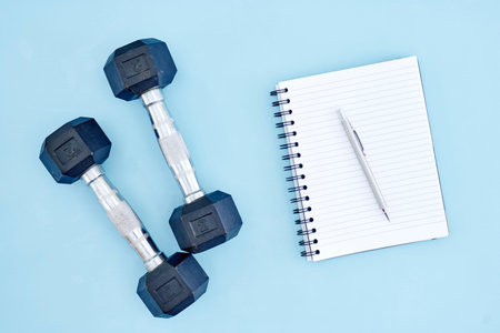 A studio photo of a black gym dumbbell