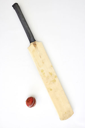 A studio photo of cricket gear on grass