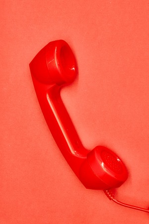 A studio photo of a red rotary telephoneの写真素材