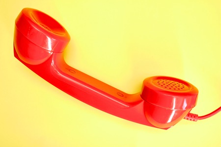 A studio photo of a red rotary telephoneの写真素材