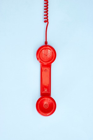 A studio photo of a red rotary telephoneの写真素材