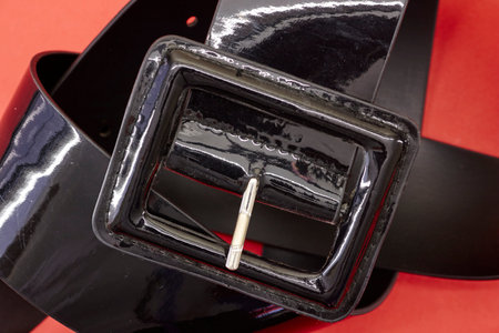 A studio photo of a black clothing belt