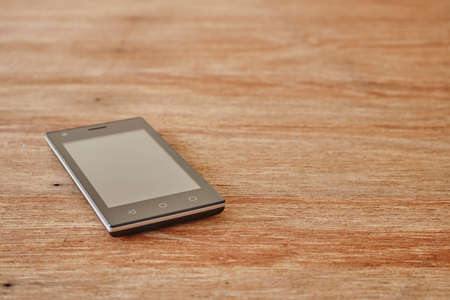 A studio photo of a mobile phone with headphonesの写真素材