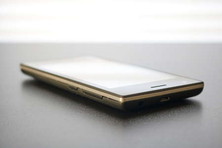 A studio photo of a mobile phone with headphonesの写真素材