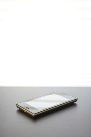 A studio photo of a mobile phone with headphonesの写真素材