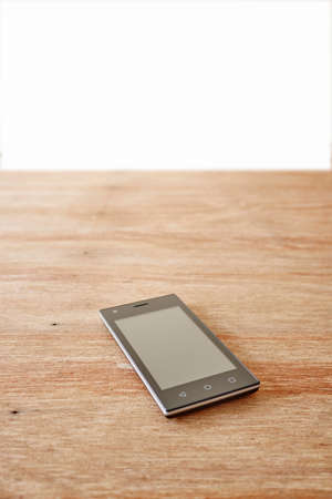A studio photo of a mobile phone with headphonesの写真素材