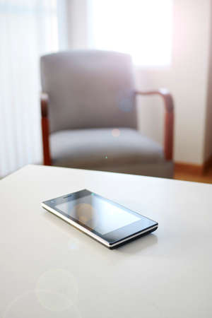 A studio photo of a mobile phone with headphonesの写真素材