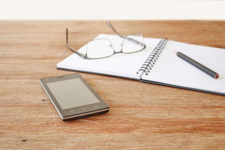 A studio photo of a mobile phone with headphonesの写真素材