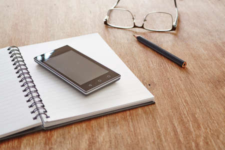 A studio photo of a mobile phone with headphonesの写真素材