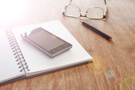 A studio photo of a mobile phone with headphonesの写真素材
