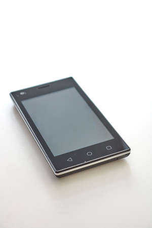 A studio photo of a mobile phone with headphonesの写真素材