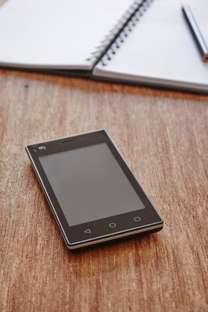 A studio photo of a mobile phone with headphones