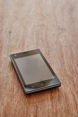 A studio photo of a mobile phone with headphonesの写真素材