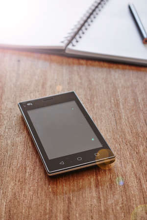A studio photo of a mobile phone with headphonesの写真素材