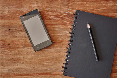 A studio photo of a mobile phone with headphonesの写真素材