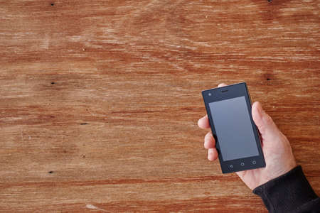 A studio photo of a mobile phone with headphonesの写真素材