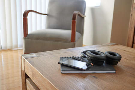 A studio photo of a mobile phone with headphonesの写真素材