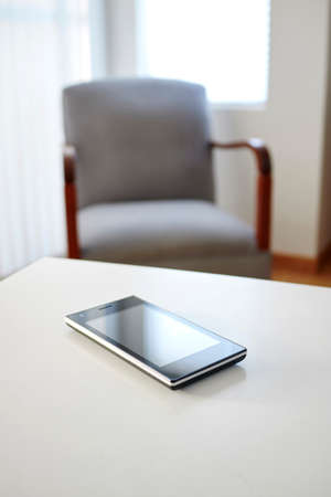 A studio photo of a mobile phone with headphonesの写真素材