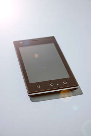 A studio photo of a mobile phone with headphonesの写真素材