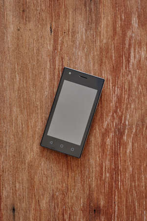 A studio photo of a mobile phone with headphonesの写真素材