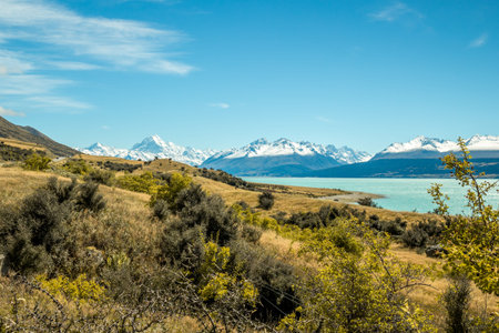 beautiful landscape shot of mount cook and snow covered mountains around in new zealand south island with green countryside in the forgroundの写真素材