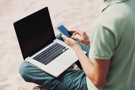 Young man working on laptop outdoor, freelance working, social networks conceptの写真素材