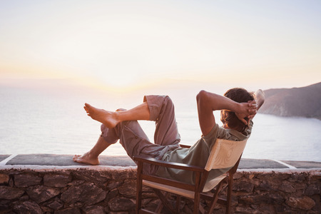 Enjoying life. Young man looking at the sea, vacations lifestyle conceptの写真素材