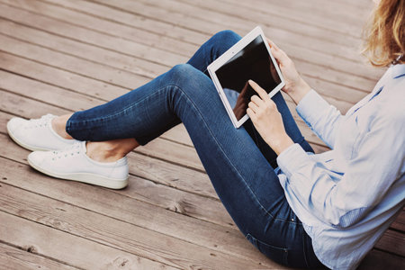 Young woman using digital tablet outdoors