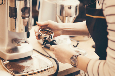 Barista preparing coffee in a coffee shop. Professional coffee making, service and catering conceptの写真素材